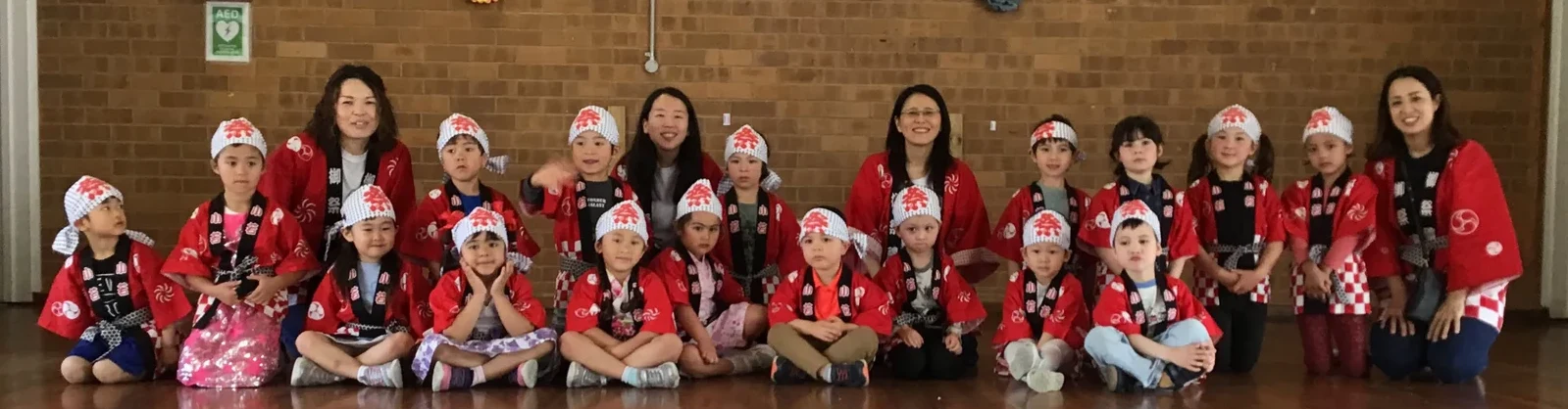 CJC Japanese Kindergarten children and teachers in red happi coats on stage at the CJC Spring Festival